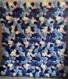 a crocheted blue and pink blanket with flowers on it