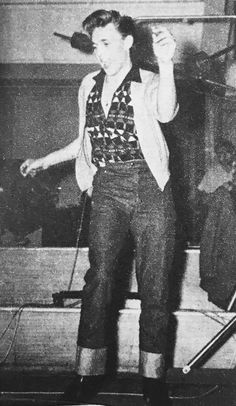 an old black and white photo of a man on stage