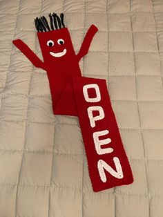 a red scarf with the word open written on it and a smiling face drawn on it