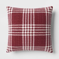 a red and white plaid pillow sitting on top of a wall