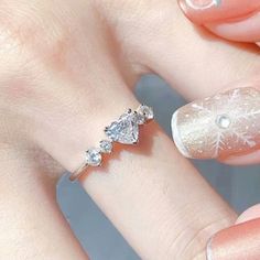 a woman's hand with three diamond rings on her finger and one ring is in the shape of a snowflake