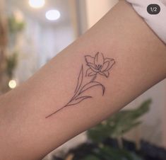 a woman's arm with a flower tattoo on the left side of her arm