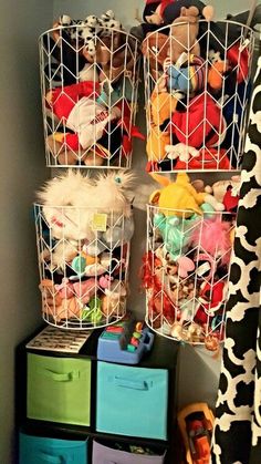 three baskets filled with stuffed animals on top of a shelf next to other toy bins