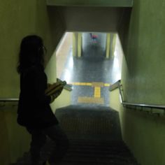 a woman is walking up the stairs in an elevator