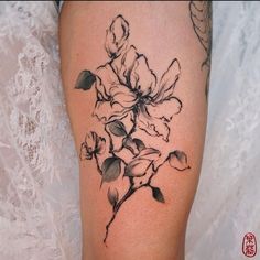 a black and white flower tattoo on the leg