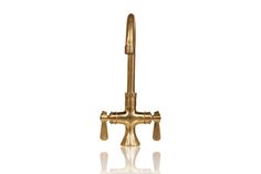 an antique brass faucet with water spouting from the side on a white background