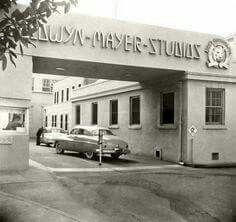 an old car is parked in front of a building