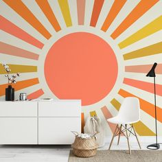 an orange and yellow sunburst wall mural in a living room with white furniture