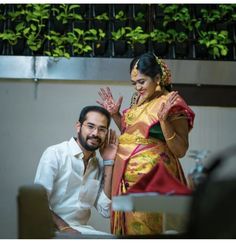 a man standing next to a woman in a yellow and red sari on her wedding day