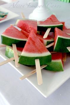 watermelon and lime popsicles are on a white plate with toothpicks