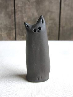 a gray cat figurine sitting on top of a table