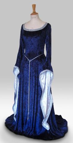 "ISOLDE IS A STUNNINGLY ELEGANT DRESS PICTURED IN NAVY BLUE AND SILVER, ALSO PICTURED IN SILVER AND ROYAL BLUE, BOTTLE GREEN AND IVORY AND PURPLE AND WHITE. DESIGNED AND CUSTOM MADE BY frockfollies AND WOULD BE PERFECT FOR SO MANY OCCASIONS: GOTHIC EVENTS MEDIEVAL/RENAISSANCE/ELVISH WEDDINGS LARP EVENTS RE ENACTMENTS HANDFASTING CEREMONIES LARP EVENTS MASQUERADE  BALLS YOUR INNER GODDESS MOMENTS! HAND MADE IN ENGLAND BY AN EXPERIENCED THEATRICAL COSTUMIER THIS OUTFIT IS AVAILABLE TO ORDER IN A WIDE RANGE OF COLORS. MADE FROM A LUXURIOUS SOFT DRAPEY  NAVY BLUE CRUSHED VELVET, THIS DRESS IS FLUID IN IT'S SIMPLICITY.  THE CLASSIC MEDIEVAL  SLEEVES WHICH ARE  LINED IN SILVER ARE TRIMMED WITH SILVER BRAID AS IS THE FLATTERING CURVED NECKLINE. A SILKY SASH CORD BELT FINISHED WITH SILVER  FILLIGR Elvish Dress, Handfasting Dress, Medieval Wedding Dress, Gothic Gowns, Medieval Gown, Medieval Wedding, Fantasy Gowns, Medieval Dress, Medieval Clothing