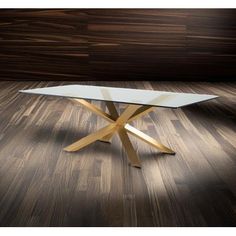 a glass table sitting on top of a hard wood floor next to a wooden wall