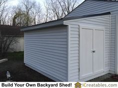 a white shed sitting in the middle of a yard