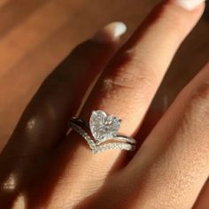 a close up of a person's hand with a diamond ring on their finger