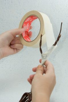 a person is using a pair of scissors to cut a piece of tape off of the wall