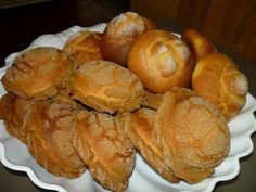 a white plate topped with rolls covered in powdered sugar