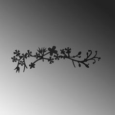 a black and white photo of a branch with flowers in the middle, against a gray sky