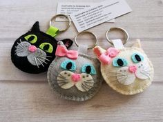 two key chains with cats on them sitting next to each other