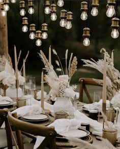 an outdoor dinner table set up with white and gold decorations