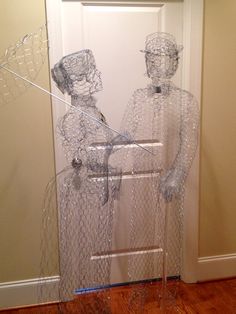 two plastic figures are standing in front of a door