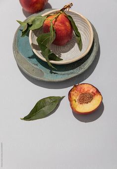 two pieces of fruit sitting on top of a plate next to another piece of fruit