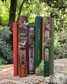 three books are stacked on top of each other in the shape of doors and windows