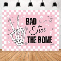 a pink poster with the words bad two the bone on it in front of a wooden floor