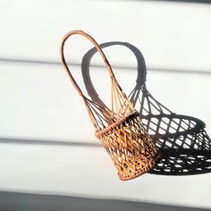 two wicker baskets sitting next to each other on a white surface with sunlight coming through the window