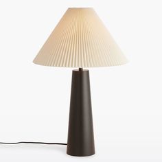 a lamp that is on top of a white surface with a cord attached to it