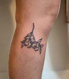 a small tattoo on the leg of a man's lower body, with flowers and leaves