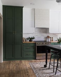 a kitchen with green cabinets and wooden floors