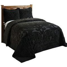 a bed with black bedspread and pillows