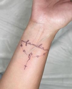 a woman's wrist tattoo with the word family written on it and hearts in the middle