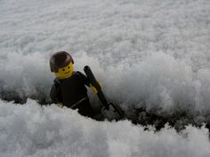 a lego man is sitting in the snow