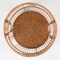 a round wicker basket with leather handles on a white background, top view photo taken from above