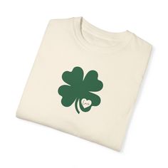 "Celebrate St. Patrick's Day in style with this charming t-shirt featuring a vibrant four-leaf clover design with \"Love\" written inside a heart on the clover! This festive shirt is perfect for adding a touch of luck to your holiday wardrobe. Made from soft and comfortable material from Comfort Colors, it is ideal for all-day wear and is sure to bring a smile to your face. Whether you're attending a parade or enjoying a cozy night in, this St. Patrick's Day t-shirt is the perfect choice for spreading some Irish cheer! Show your love of St. Patrick's Day with this comfy graphic tee.  It also makes the perfect gift for a friend, boyfriend, girlfriend, or for YOU!! This classic unisex jersey short sleeve tee fits like a well-loved favorite. Soft cotton and quality printing will make you fall Irish Cheers, Clover Design, Festival Shirts, Holiday Wardrobe, Cozy Night, Comfort Colors Tee, Saint Patrick, Four Leaf, Leaf Clover