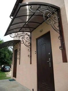 a black door is on the side of a building with an awning over it