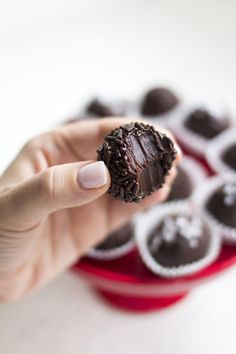 a hand holding up a chocolate covered doughnut