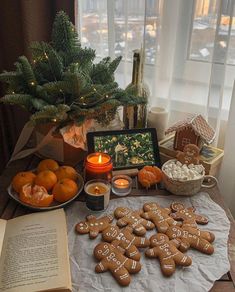 gingerbreads and oranges are arranged on a table next to an open book