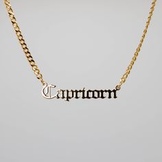 a gold necklace with the word charm on it