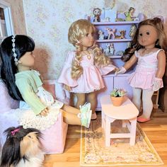 three dolls are playing with their pet dogs in the living room