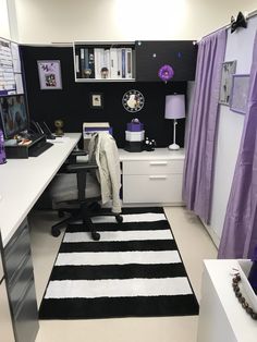 a black and white rug in an office with purple drapes on the windowsill