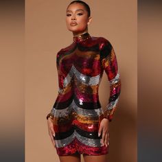 a woman in a red and black dress with sequins on her body is posing for the camera