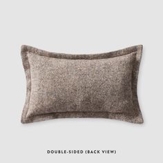 a brown pillow sitting on top of a white wall next to a gray and black sign that says double - sided back view