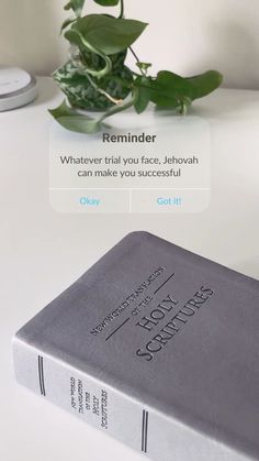 a book sitting on top of a white table next to a potted green plant