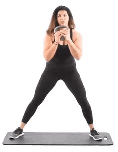 a woman is standing on a yoga mat with her cell phone in front of her