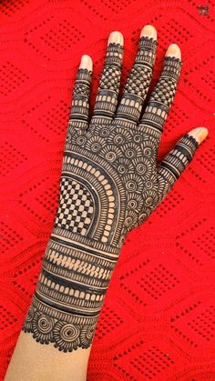 a woman's hand with hennap on top of red tablecloths