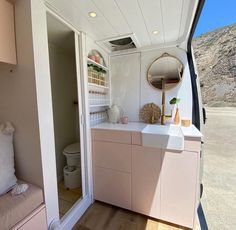 the interior of an rv with white walls and wood flooring, including a sink