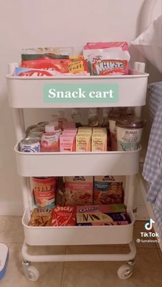 a snack cart with snacks on it next to a bed